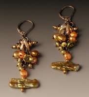 earring of dangling pearls of different sizes, colors and shapes.